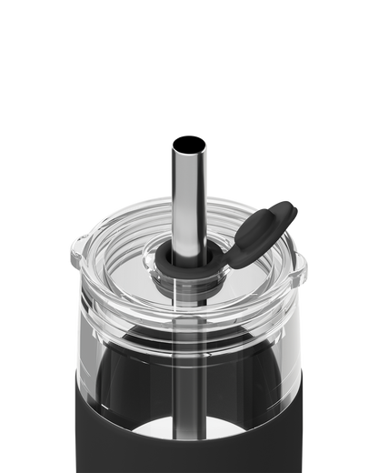 Close-up of a clear plastic tumbler with a black silicone sleeve, a stainless steel straw, and a black flip-top lid on a white background.