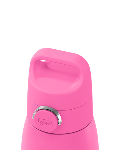 Close-up of a bright pink reusable bottle lid with a carry handle and a silver metal button, branded 'frank green', on a white background.