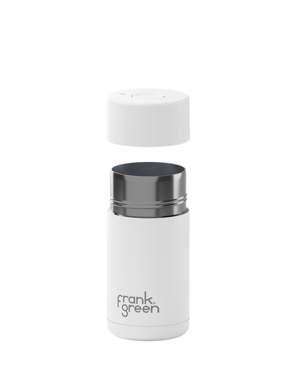 A white insulated bottle with its cap removed and floating above the opening, shown on a clean white background. The bottle has a dark metallic rim and the brand name 'frank green' printed near the bottom.