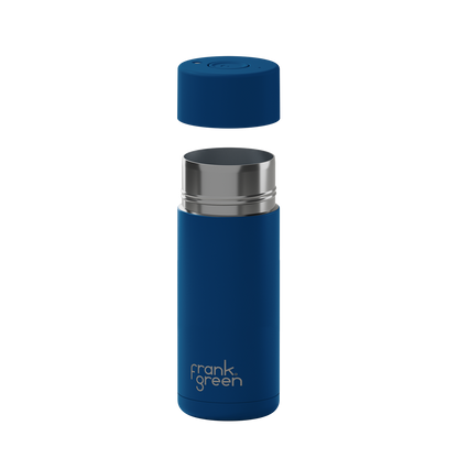 A blue vacuum-insulated travel tumbler with a matching blue cap floating above the open top, featuring a silver stainless steel rim and the 'frank green' logo near the bottom, shown on a plain white background.