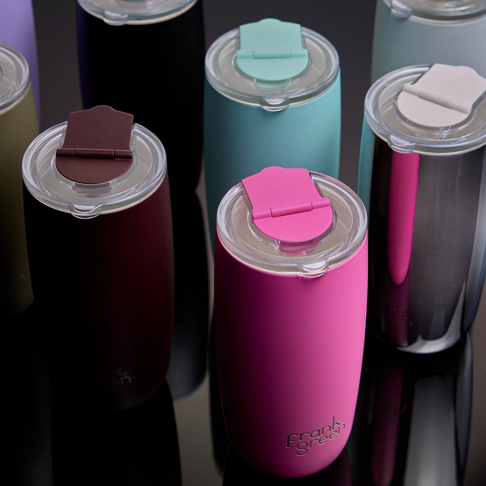 A group of insulated travel tumbler cups with flip-top lids, shown in multiple colors including pink, teal, burgundy, black, and silver, with the brand name 'Frank's Street' visible on the front pink cup.